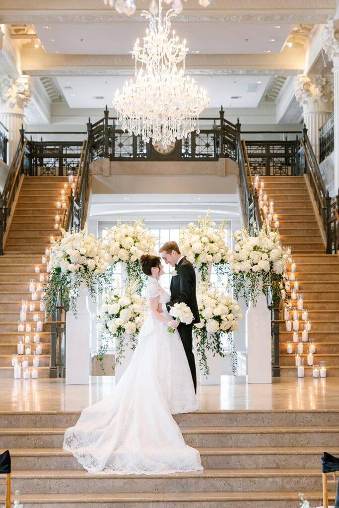 Corinthian-Houston-wedding-couple-photos-ceremony-photos-candles-on-stairs-grand-florals-for-ceremony