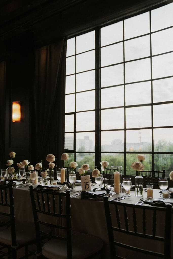 modern-astorian-wedding-custom-menus-black-bows-rose-floral-centerpieces-stone-table-numbers